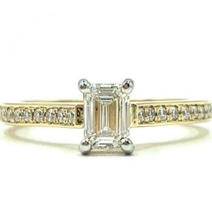 Emerald Cut Engagement ring featuring a solitair diamond center stone with a pave set diamond side channel on a sleek band